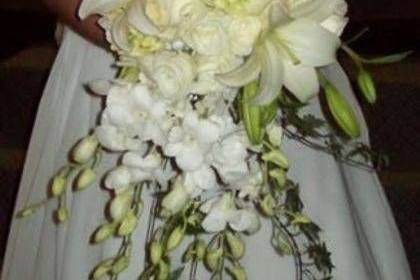 Cascading all white with orchid, Lilly, roses and Hydrangea.