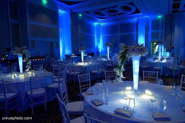 The room was illuminated blue with centerpiece illuminated a soft white.  Three different floral arrangements dressed the tables, one with dripping open cut calla lilies, one with huge white hydrangea ball with dripping calla lilies and the third with towering branches to flow with the 14 foot custom built white birch trees for both the ceremony adn reception.