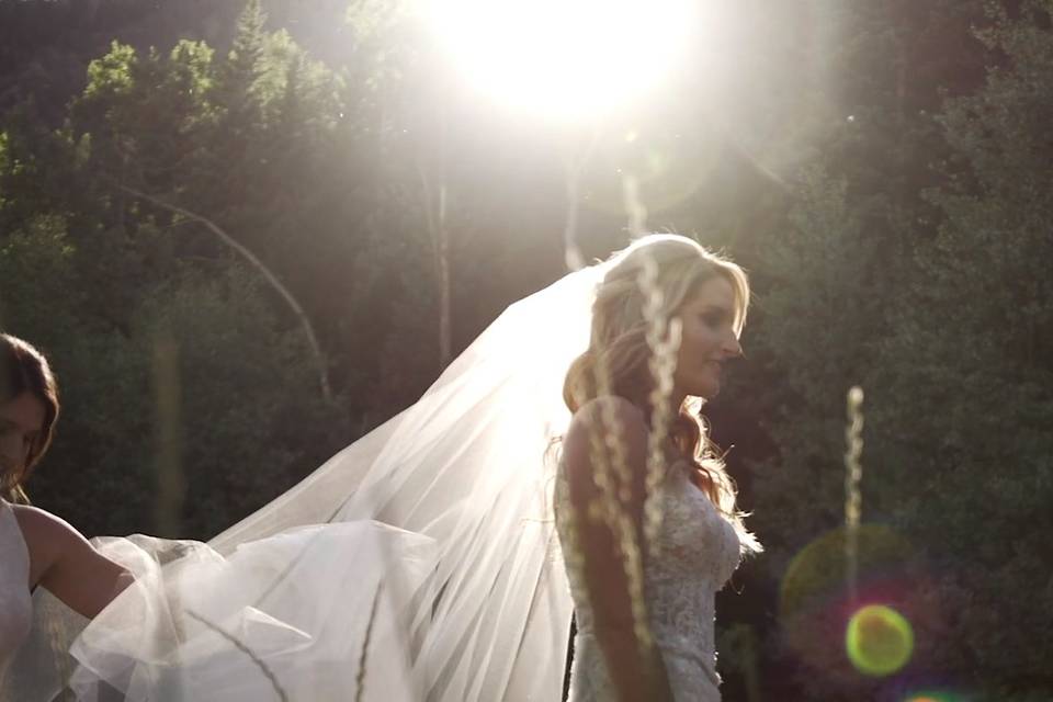 Bridesmaid helping bride with veil