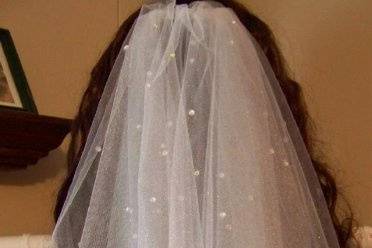 This is a full circle cut, elbow length, white shimmer tulle veil that is double faced trimmed with rhinestones. This was a custom order for a summer wedding.