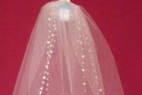 This is our sweetheart cut veil it is made with white tulle, three tiers, and trimmed with a unique alternating rhinestone and white pearled edgeing
