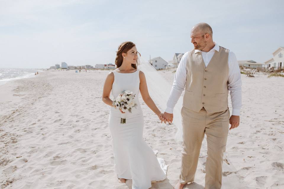 Bride and groom walking beach