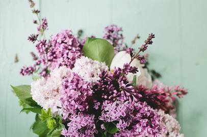 An all natural Spring Bridal Bouquet of freshly cut Lilacs, French Lavender, Peony, Geranium & Hosta leaves bound with twine.