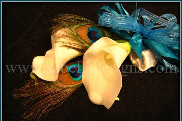 Beautiful white calla lillies and peacock feathers wrapped in a turquoise bow