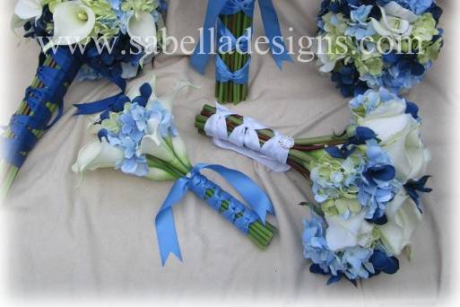 Blue and green hydrangea with creamy white roses, calla lillies, and orchids make up this assorted wedding bouquet family.