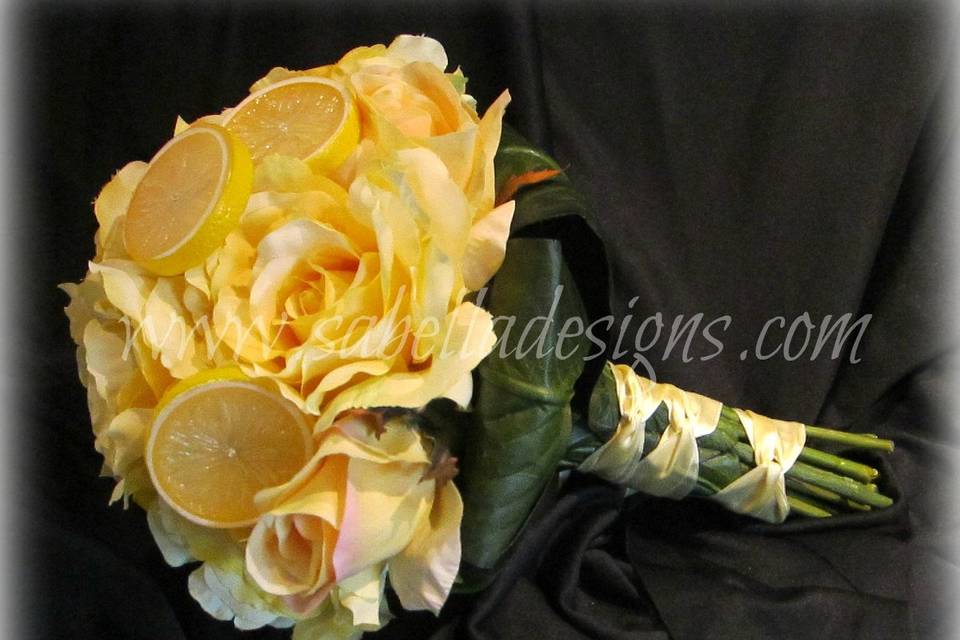 Stunning bouquet with creamy yellow roses, green leaves, and lemon accents make this a bouquet to remember.