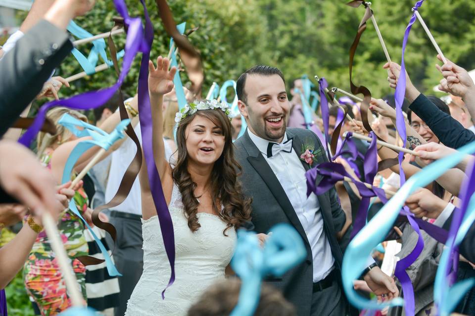 Married couple among guests with streamers at Kittle House Wedding. ©2018 Fort Point Media LLC, All Rights Reserved.