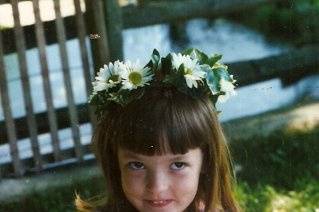 This lovely young model is wearing a daisy wreath and holding a daisy ball.