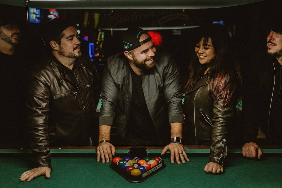 Band posing by a pool table