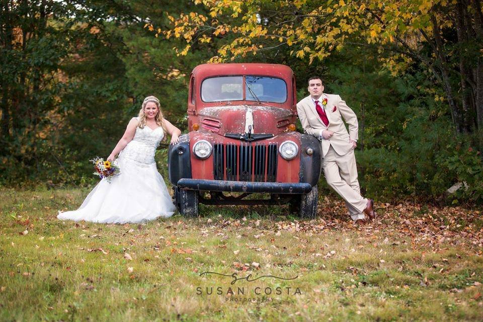Newlyweds posing with vintage car