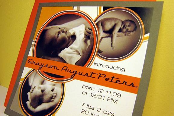 Custom birth announcement with a circle motif in orange and gray.