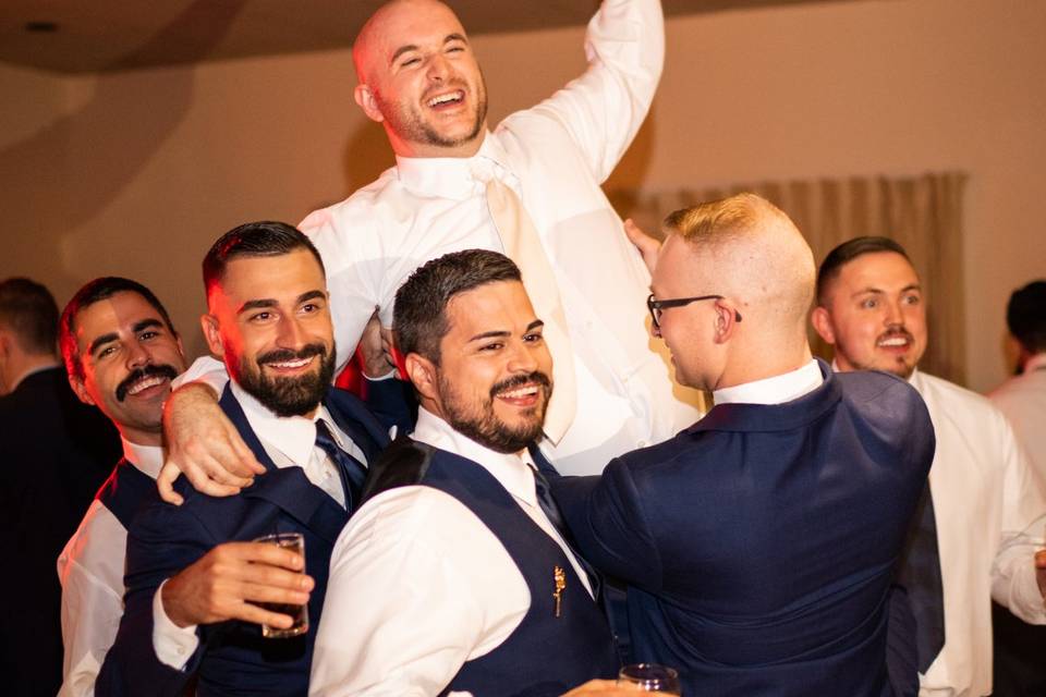 Groomsmen hold up Groom