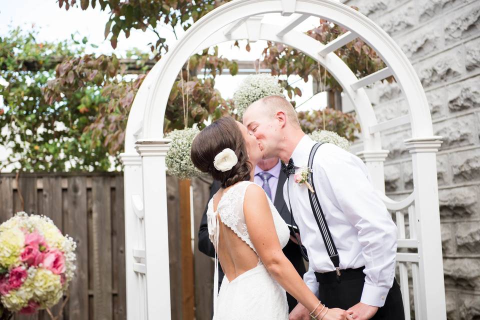 Outdoor arch ceremony kiss