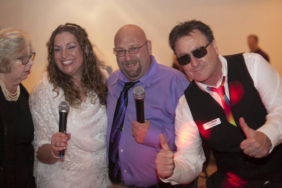 DJ Buddy of Let's Party! DJs teaching happy couple Marci & Elliot how to use the microphones.  We loved partying with them.  They had a Grateful Dead themed wedding!!!