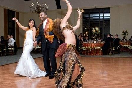 Belly dancer interacts with bride and groom