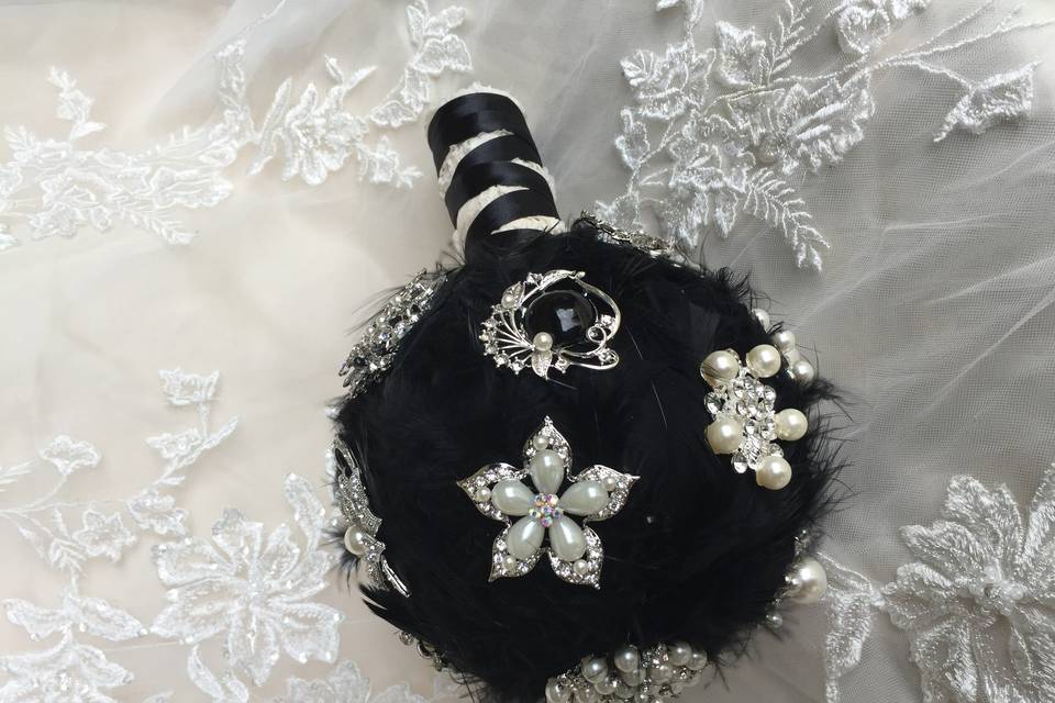 Black feather and brooch bouquet. This is a unique bridesmaid bouquet or bridal bouquet. It was originally made as a matching bridesmaid bouquet to a larger brooch bouquet.