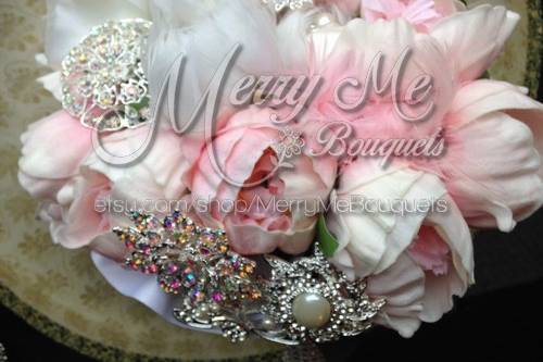 This is a true touch bouquet with peonies and silvertoned brooches and feathers.
