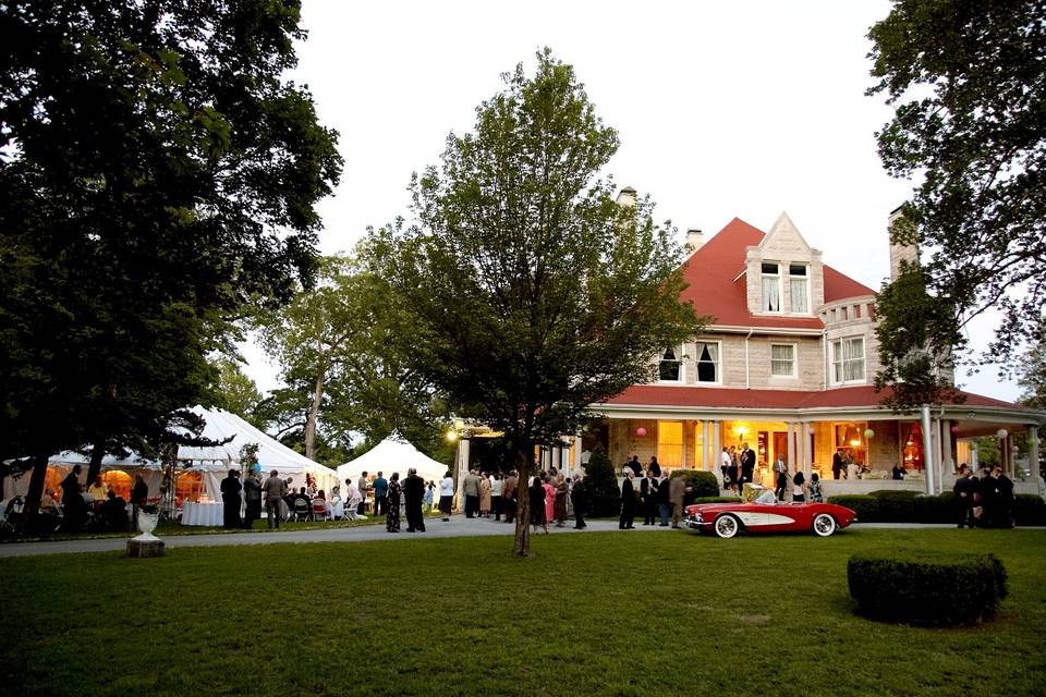 A beautiful view from the street of the house with tents set up on the grounds