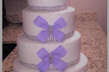 White wedding cake with purple bows