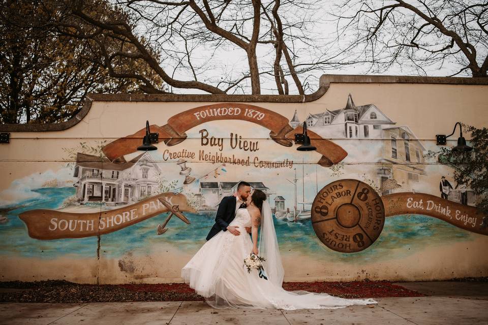 Couple kissing by mural