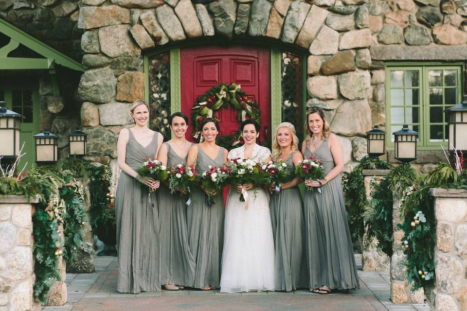 Bridal party by red door entrance with holiday decor | Leona Campbell Photography