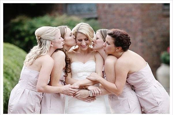 Bridesmaids kiss the bride