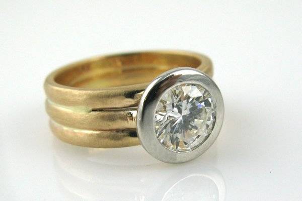 1 ctw diamond bezel set in platinum with 14K yellow gold band.