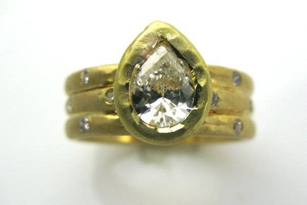 1 ct pear shaped diamond was set in 14K yellow gold hand hammered setting. Shown with diamond accents.