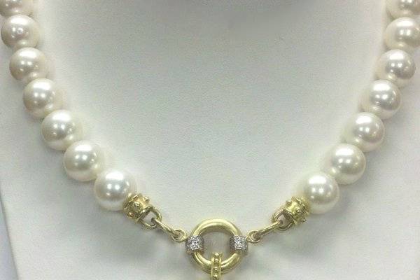 Made a monogrammed enhancer with your new initials and wear it on a strand of pearls for a more modern look! 14K yellow gold with diamond accents.