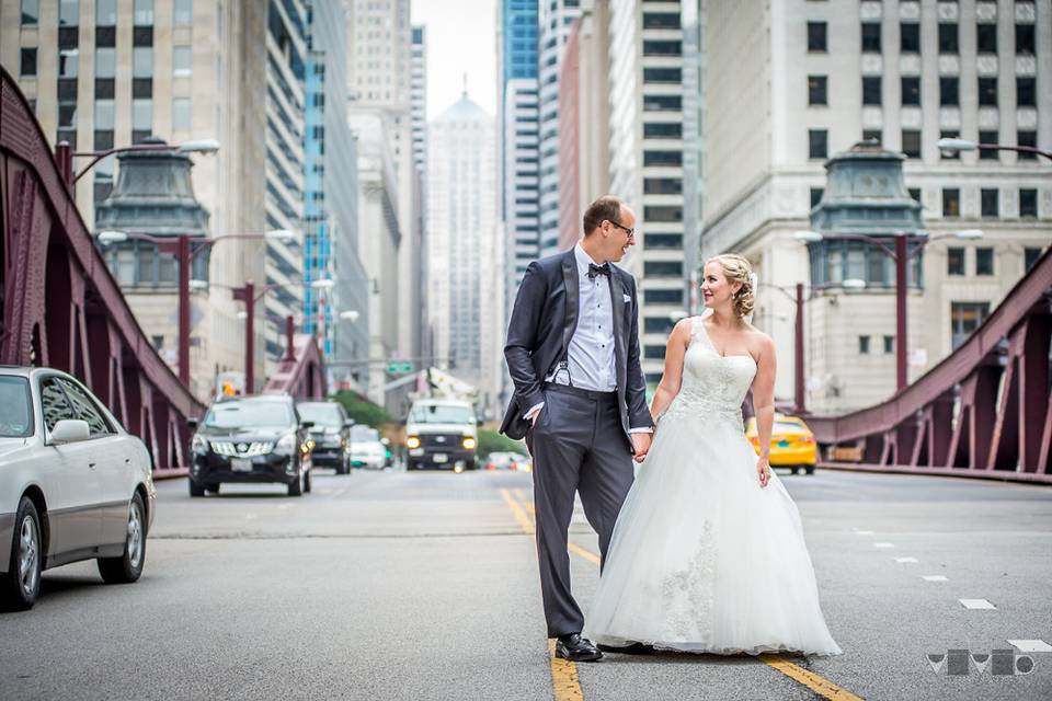 Bride and groom in the middle of a busy downtown Chicago street.