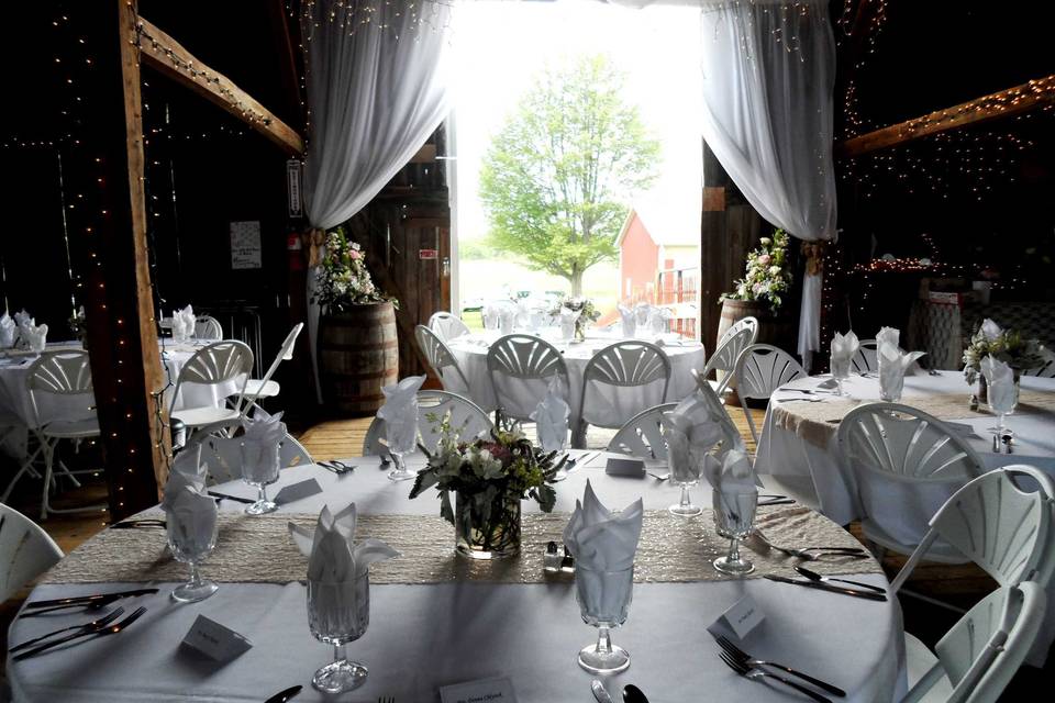 Graceful white curtains and whiskey barrels at the entrance of our barn!