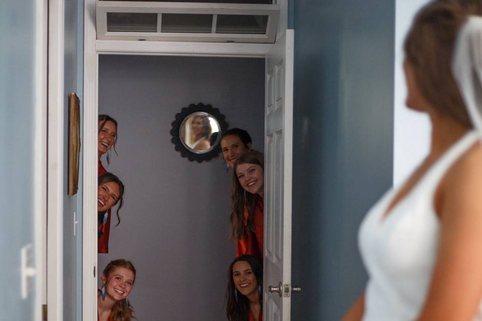 Bridesmaids peeking on bride
