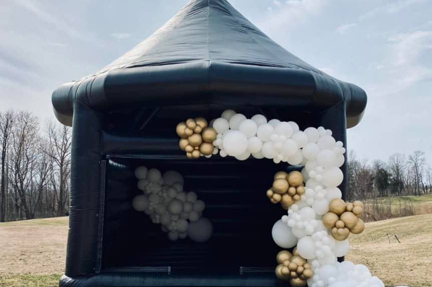 Black bounce house with balloons