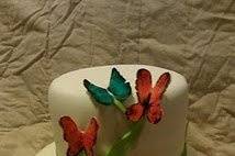 A whimsical and colorful two tiered cake with hand cut and hand painted edible butterflies.