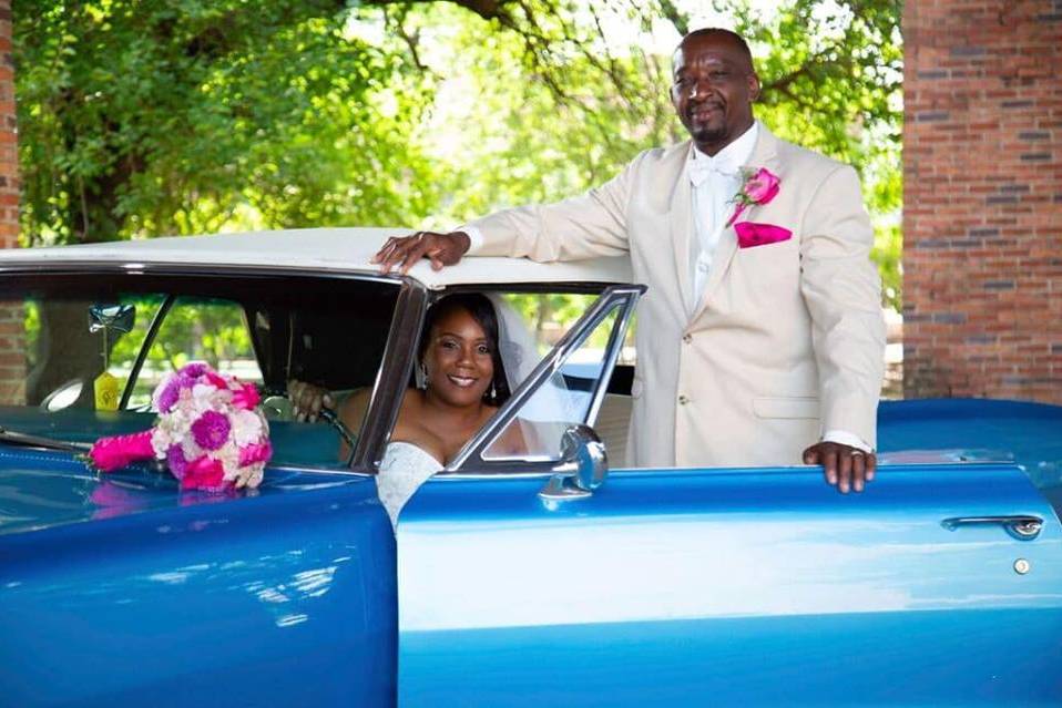 Newlyweds by their car