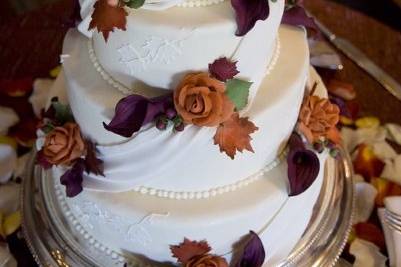 Delicate sugar drapes, accented with hand-made sugar berries, fall leaves, roses and calla lilies.