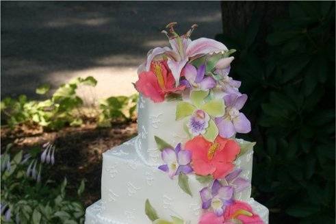Hand-made sugar hibiscus, anthuriums, stargazer lilies and orchids on monogrammed buttercream tiers......