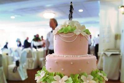 Dogwood blossoms and hydrangeas made of sugar, on buttercream tiers adorned with sugar pearls....