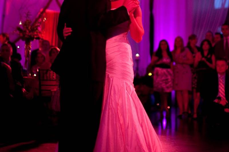 Couple dances in pink and purple lighting