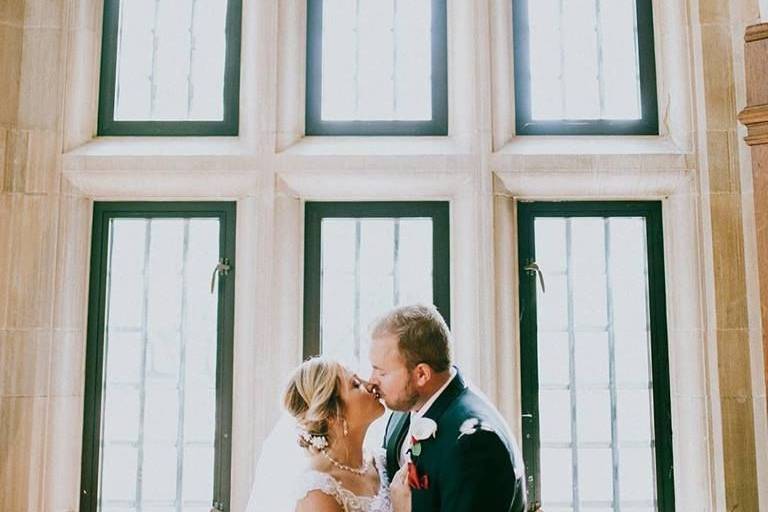 Newlyweds kiss by the windows