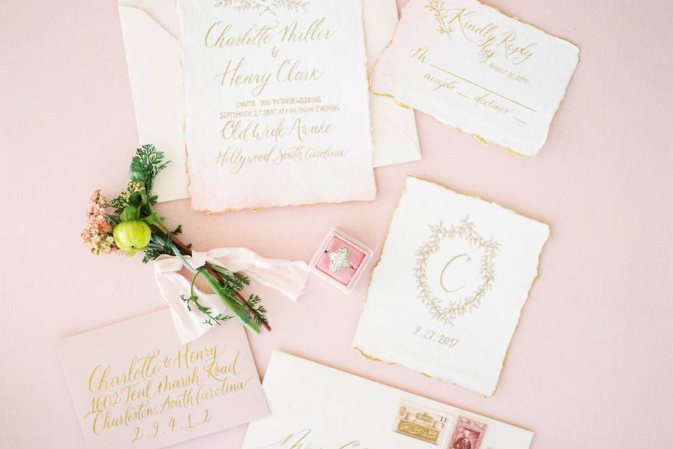 Romantic pink and gold invitation suite with bespoke wedding crest, watercolor washed and gold hand painted edges on handmade cotton paper.
