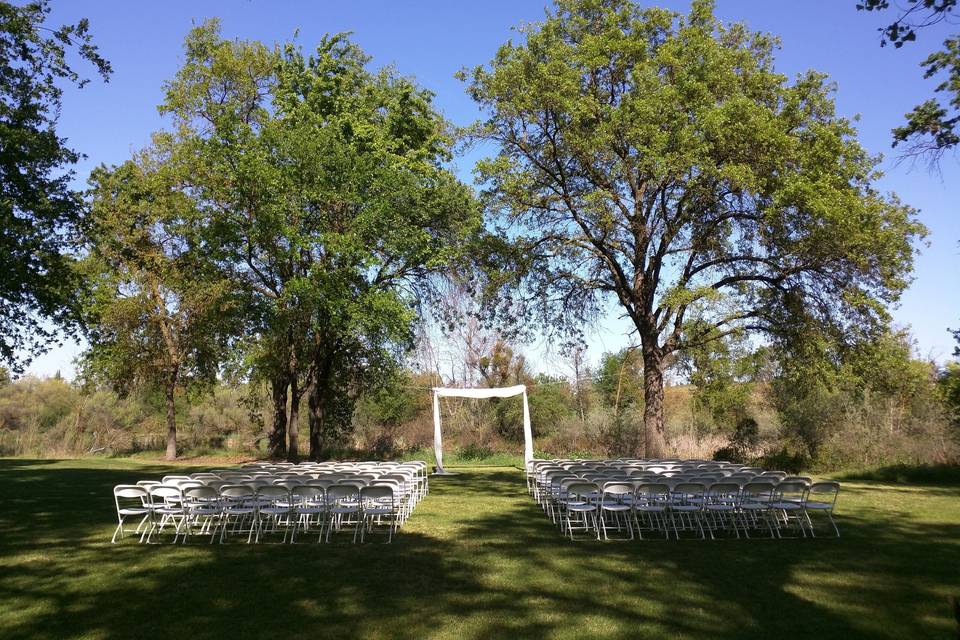 Sweet ceremony space on our River Lawn || Draped arch by the groom!