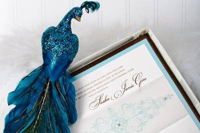 Custom designed multi-layer wedding invitation inside a textured silk covered box. Three Swarovski were precisely placed on the scroll-like design printed on the vellum bellyband.