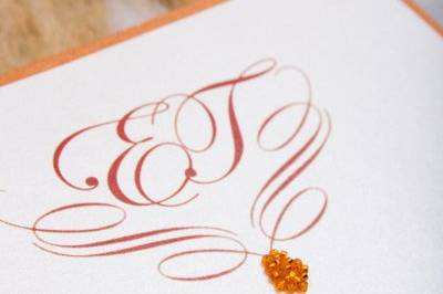 Custom designed 2 layer wedding invitation. Orange crystal seeds were miticulously glued to create a tear drop at the base of the monogram. The monogram was used as a general theme throughout the wedding.