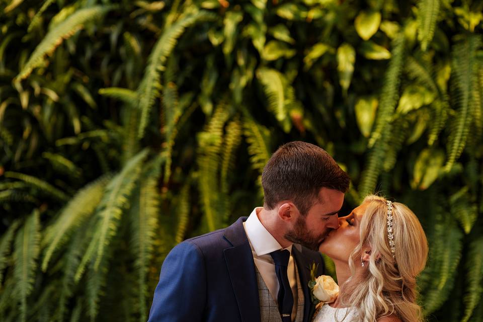 Couple in front of greenery