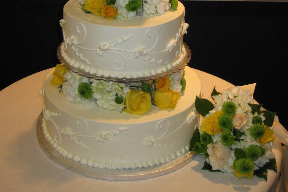 Yellow and green flowers carry the wedding theme onto the wedding cake.