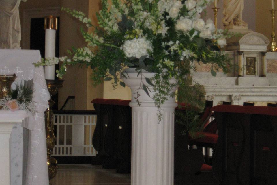 Classic altar pieces are designed with calla lilies, roses, orchids, snapdragons and larkspur.