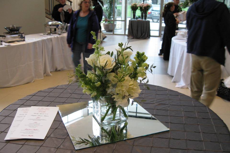 All white centerpiece in a cube vase makes a simple yet elegant statement.