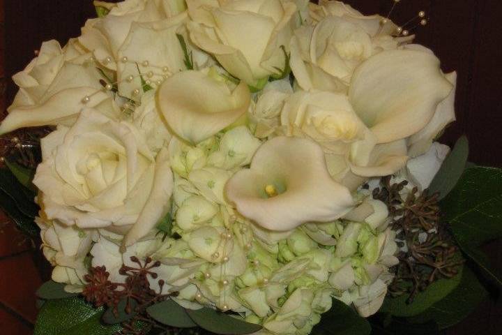 Romantically classic bridal bouquet featuring roses, mini calla lilies and hydrangea.