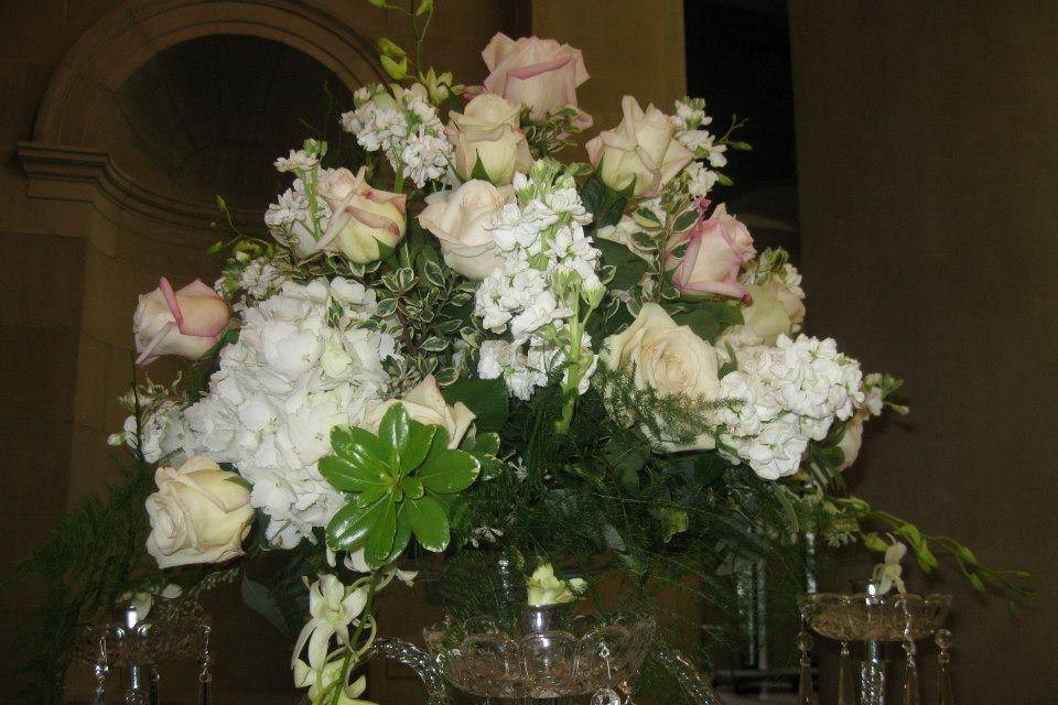 Lavish candelabra centerpieces overflowing with hydrangea, roses, fragrant stock, and orchids.